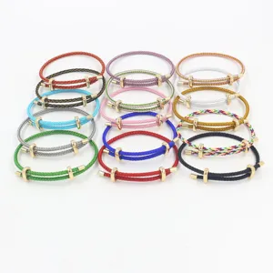 Detalle de pulseras ajustables de cable de acero con hebillas doradas en ocho en varios colores