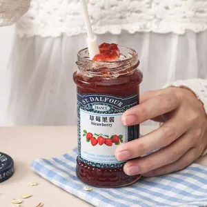 Hitzebeständiger weißer Silikon-Backspatel rührt Erdbeermarmelade in einem Glas