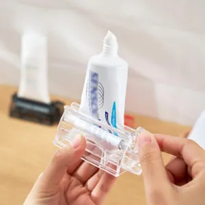 Gros plan d'un presse-dentifrice en plastique transparent utilisé à la main