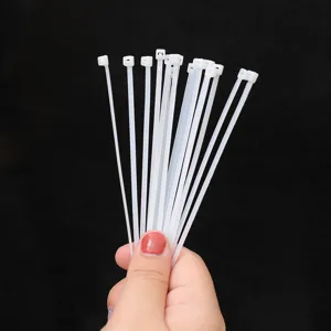 Bundle of durable white self-locking nylon plastic cable ties for wire management and binding
