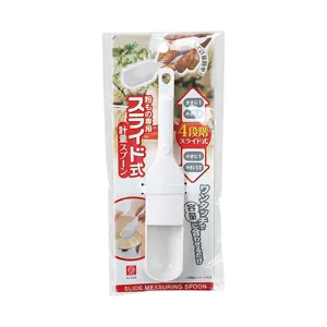 Adjustable white plastic measuring spoon with 4-level scale in retail packaging for kitchen