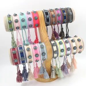 Detailansicht böhmischer gewebter Armbänder mit Metallnieten und Quasten auf Holzständer