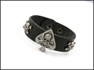 Detalle de una pulsera de cuero negro de estilo punk con remaches de calavera y picas.