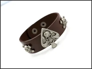 Detalle de brazalete punk de cuero marrón con tachuelas de calavera y picas