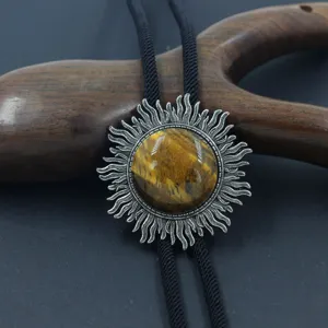 Primer plano detallado de un colgante de corbata bolo vintage con forma de sol y ojo de tigre