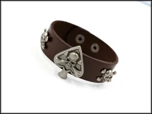 Detalle de pulsera punk de cuero marrón con tachuelas metálicas de calavera y picas