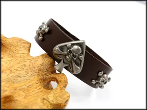 Vista detallada de los remaches de calavera punk en el brazalete ancho de cuero marrón para hombres