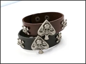 Vista detallada de pulseras de cuero punk con tachuelas de calavera y picas en marrón y negro.