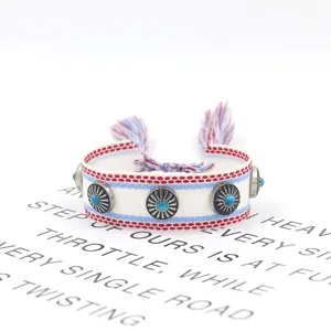 Nahaufnahme eines handgewebten Ethno-Armbands mit Metallnieten und blauen Türkissteinen