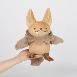 Vue détaillée d'une peluche de chauve-souris Polliwog marron tenue à la main pour l'échelle