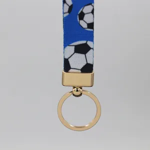 Primer plano del cordón de muñeca azul con estampado de fútbol y anilla de metal dorado