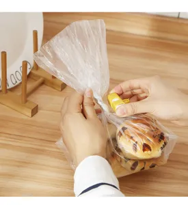 Primo piano di una clip di chiusura elastica gialla applicata a un sacchetto di pane in cucina.