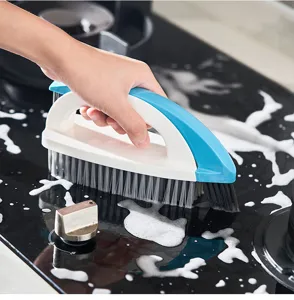 Détail de la brosse multifonction bleue et blanche nettoyant une cuisinière