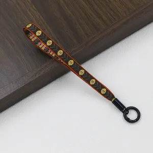 Ethnic style woven short strap lanyard with floral pattern and black circular metal clasp