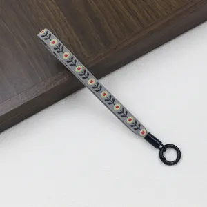 Ethnic style embroidered grey lanyard with black circular clasp for phone keys.