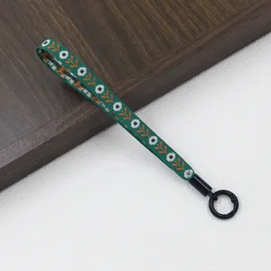 Ethnic style woven green wrist lanyard with orange tree pattern and black ring clasp