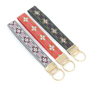 Vue détaillée de porte-clés ethniques en jacquard avec motifs floraux et ferrures dorées.