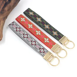 Gros plan sur trois porte-clés ethniques en jacquard fleuri avec anneaux dorés élégants