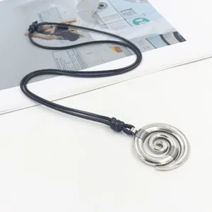 Close-up view of stainless steel spiral aromatherapy diffuser pendant on black cord