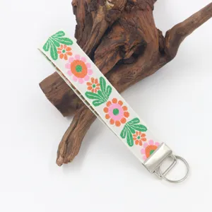 Primer plano del llavero bordado con flores de 25 mm sobre un fondo de madera rústica
