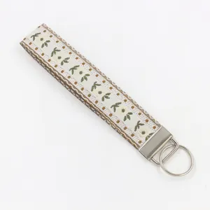 Detailansicht eines gewebten Jacquard-Schlüsselanhängers mit Blumenmuster und Metallring