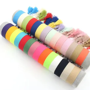 Detailed view of colorful solid woven wristbands with tassels arranged on display rollers