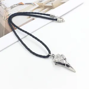 Macro detail of Viking Vegvisir symbol engraved on a retro silver crow skull pendant necklace
