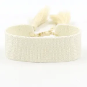 Detailed view of cream-white woven fabric bracelet with tassels for DIY embroidery projects