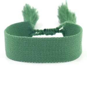 Detailed macro view of green woven ethnic style bracelet with adjustable tassels for DIY