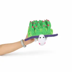 Gros plan d'une peluche de nudibranche verte créative tenue par une main humaine