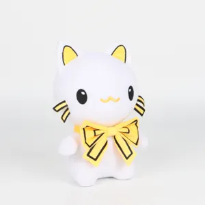 Gros plan d'une peluche de chat blanc avec un nœud jaune et une texture de tissu doux