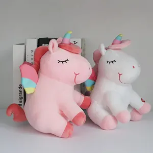 Dos simpáticos peluches de unicornio LED rosa e blanco con alas de colores suaves