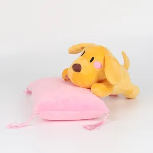 Niedlicher gelber Hundeplüsch auf einem weichen rosa Dekokissen mit Fransen
