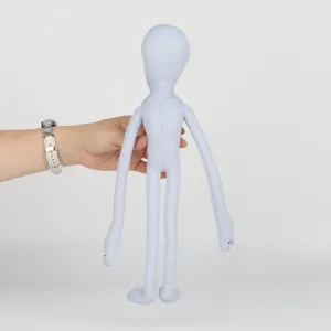 Peluche humanoïde grise à longs membres tenue à la main pour comparaison de taille
