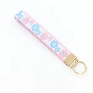 Close-up of jacquard floral embroidery on a white fabric wristlet keychain strap