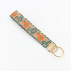 Close-up of ethnic floral embroidered jacquard wristlet keychain with gold metal ring