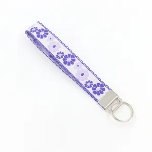Detailed view of the intricate purple flower embroidery on the jacquard keychain strap