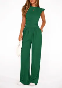 Λεπτομέρεια πράσινου ριμπ σετ δύο τεμαχίων με βολάν στα μανίκια και υφή υφάσματος.