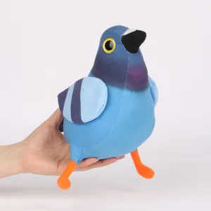 Main tenant la peluche bleue Pigeon Pop montrant sa texture douce et sa taille compacte