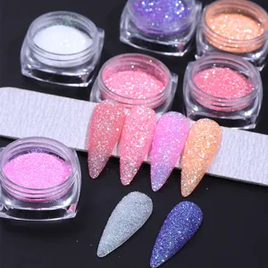 Detailed view of colorful nail sugar powder jars and glitter coated nail tips on a file