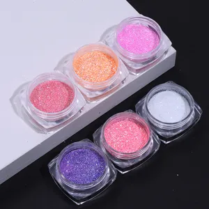 Close-up view of various colorful nail art glitter powders in transparent square jars