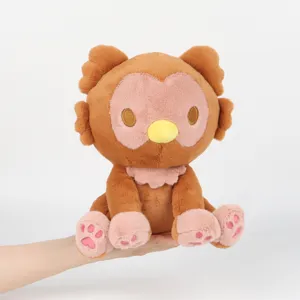 Detail showing a soft Owlbear monster plush toy held by a hand for scale