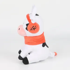 Perfil lateral de una vaca de peluche blanca con orejeras naranjas y detalle de bordado Lofi.