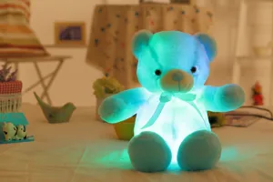 Zachte lichtgevende LED teddybeer knuffel met cyaan licht in een warme gezellige kamer