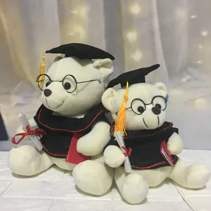 Detailweergave van twee witte afstudeer-knuffelberen in toga's en afstudeerhoeden