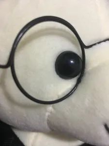 Macro-detail van een zachte witte pluche afstudeerbeer met oog en een ronde bril