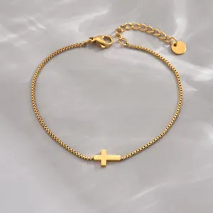 Nahaufnahme eines minimalistischen Goldarmbands mit einem eleganten Kreuzanhänger-Detail