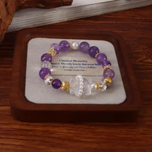 Detailansicht eines 14-mm-Naturamethyst-Armbands auf einem hochwertigen Holztablett für Schmuck