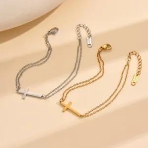 Detailansicht von silber- und goldfarbenen Edelstahl-Doppelkettenarmbändern mit Kreuzanhängern
