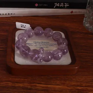 Handgefertigtes 14mm natürliches Amethyst-Perlenarmband auf einem rustikalen Holztablett
